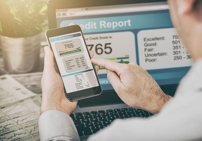 Mercado Pago: imagem de um empresário utilizando um celular para consultar o Score CNPJ da sua empresa e, ao fundo, é possível ver a tela de um notebook aberta com a imagem do Score CNPJ da empresa com as mesmas informações, indicando os principais dados.