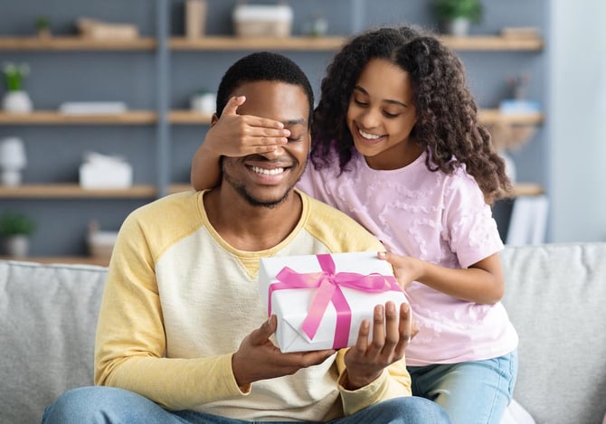 Menina surpreendendo seu pai com um presente