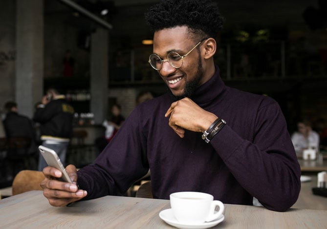 Homem com celular usando Open Finance pelo app Mercado Pago