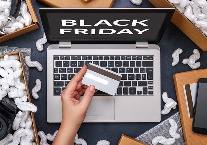 Mercado Pago: mão de empresário segurando cartão em frente ao notebook com tela da Black Friday revertendo um pagamento recusado