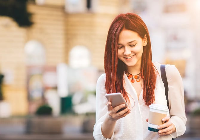 Mercado Pago: Mulher sorrindo com um café na mão enquanto mexe no celular, realizando pagamentos invisíveis