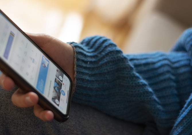 Pessoa segurando celular na mão na tela do Mercado Pago