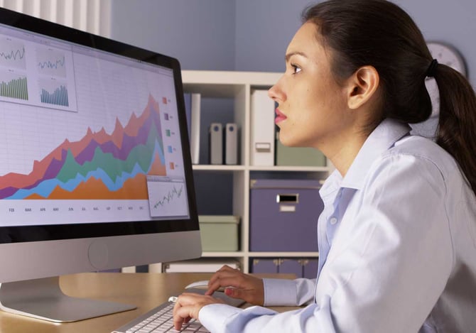 Uma mulher olhando para a tela de um computador com um gráfico