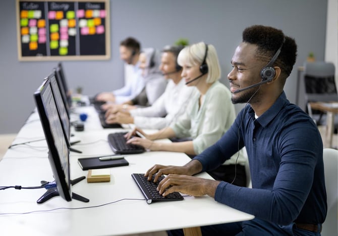 Várias pessoas em frente ao computador e com fones de ouvido conversando com clientes