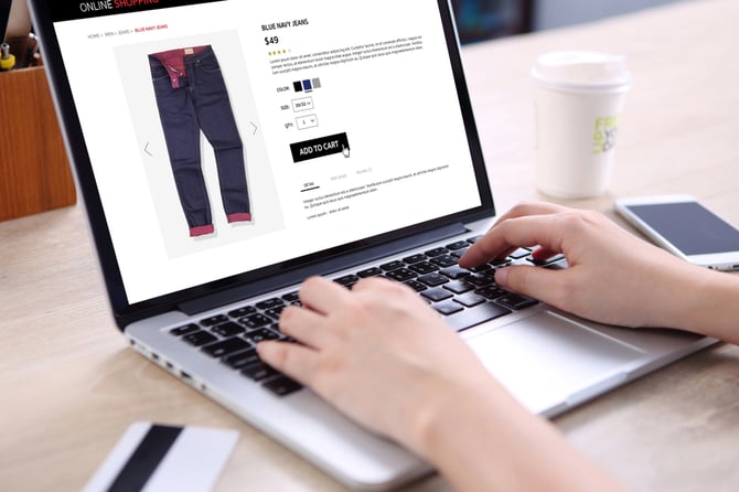 Mercado Pago: Mãos digitando em um notebook com site de compra aberto em uma calça e pessoa escolhendo a melhor solução de pagamento no marketplace.