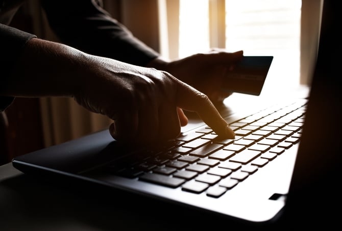 Mãos de uma pessoa mexendo no computador digitando os dados do seu cartão de crédito para fazer o pagamento de compras realizadas no e-commerce com ajuda do Mercado Pago