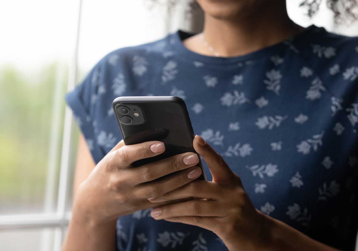 Mulher fazendo pagamentos via Open Finance pelo celular no Mercado Pago