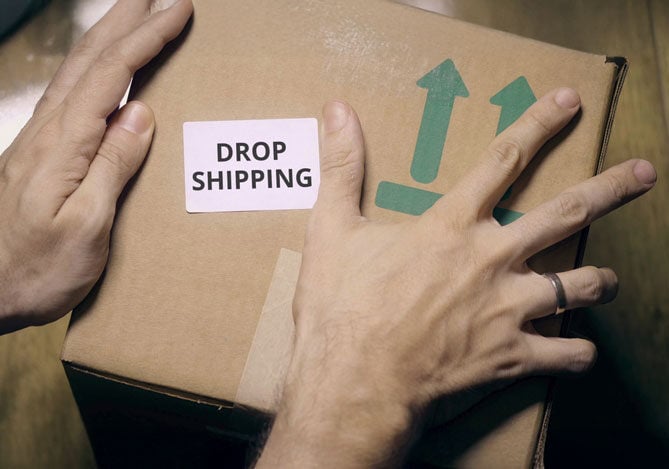 Mercado Pago: imagem das mãos de uma pessoa segurando uma caixa em que há algum produto que foi vendido por uma loja de dropshipping. Na caixa há um adesivo no qual está escrito “DROPSHIPPING”.