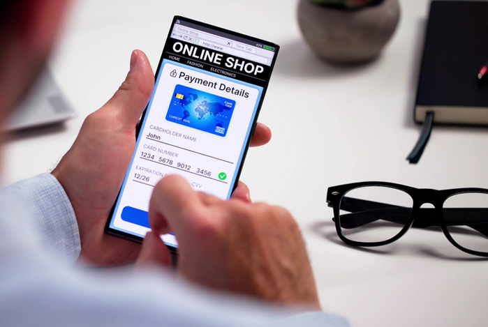 Mercado Pago e Wix: mãos de um homem mexendo no smartphone enquanto cadastra seu cartão de crédito na etapa de checkout, utilizando um gateway de pagamento.