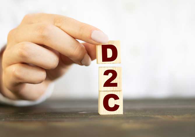 Mercado Pago: Mão de empresária empilhando bloquinhos de madeira com as letras do modelo de negócio D2C